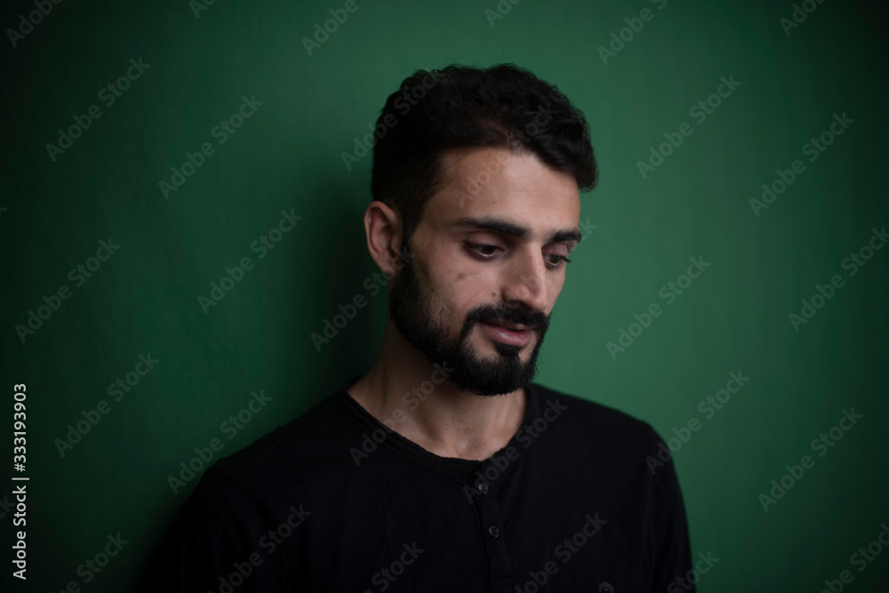 Portrait of young brunette Indian Kashmiri man in casual tee shirt in green copy space studio background. lifestyle and fashion. Portrait of young brunette Indian Kashmiri man in casual tee shirt in green copy space studio background. lifestyle and fashion.
