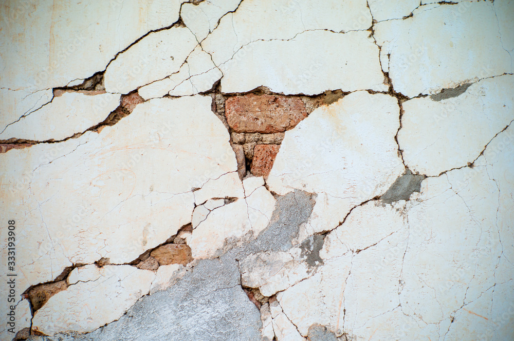 Abstract texture and background of broken plastered cement wall with red bricklayers inside