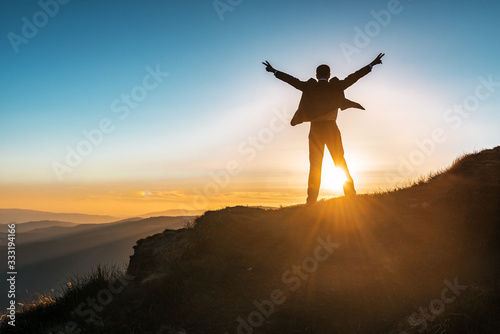 businessman in expensive suit, mountains and sunset