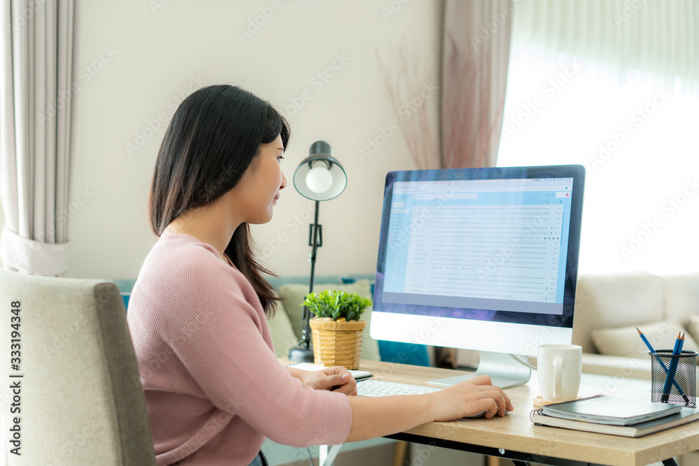 Young asian businesswoman using computer checking e-mail work from home for protect virus and take care of their health from COVID-19. Working at home and social distancing concept. Young asian businesswoman using computer checking e-mail work from home for protect virus and take care of their health from COVID-19. Working at home and social distancing concept.