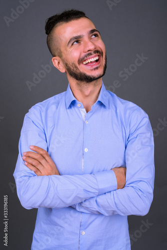 Portrait of happy bearded Turkish businessman thinking with arms crossed © Ranta Images