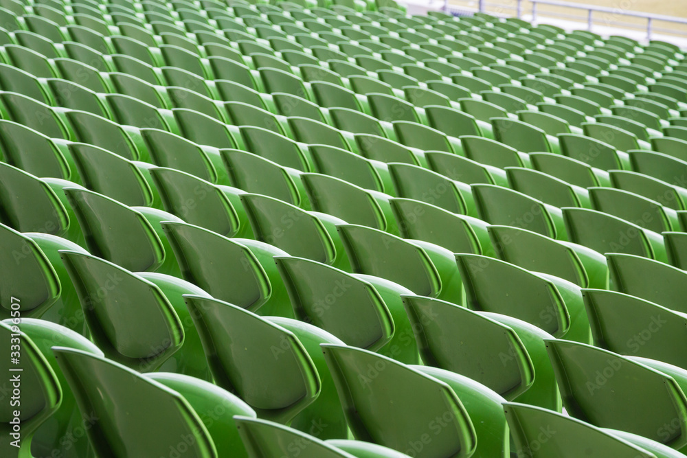 Obraz premium A row of empty green seats in a football stadium