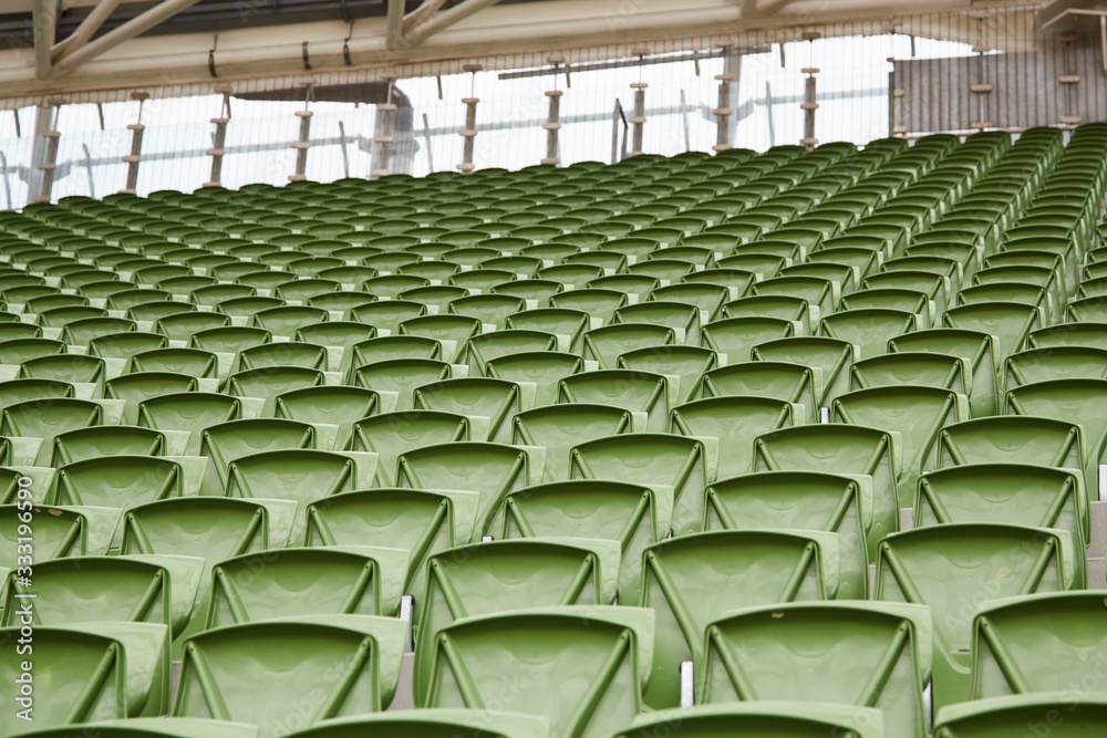A row of empty green seats in a football stadium A row of empty green seats in a football stadium