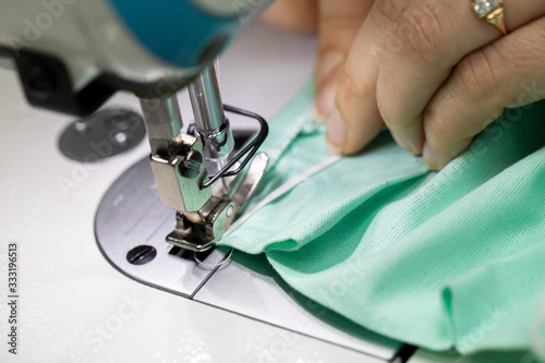 Experienced seamstress sews fabric protective masks as standard during the COVID-19 epidemic. photo