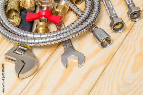 Plumbing materials, faucet, tool and hose on wooden boards are used to replace or repair
