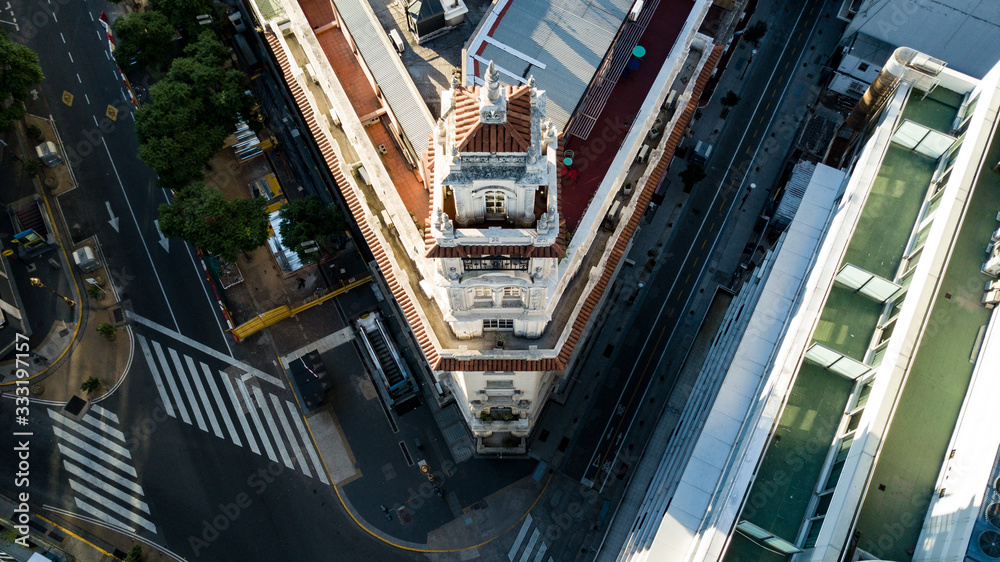 Aerial top down view on old building next to modern one during golden hour (sunset time) with no people or traffic due to corona virus quarantine - 24 March 2020