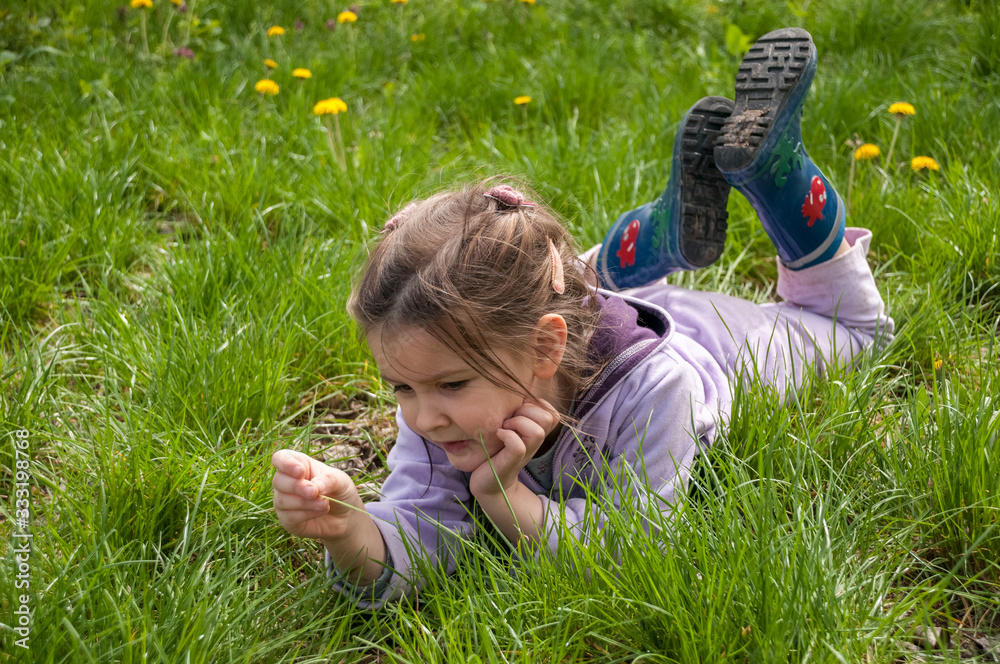 Sweet little girl take a rest on the grass in the garden