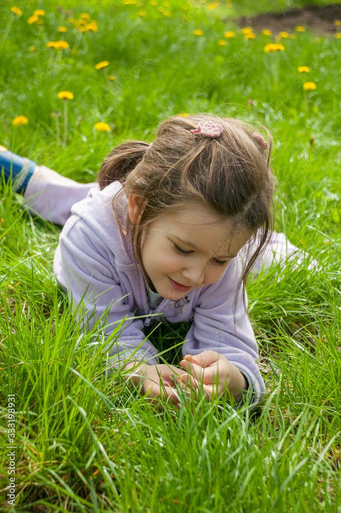 Sweet little girl take a rest on the grass in the garden