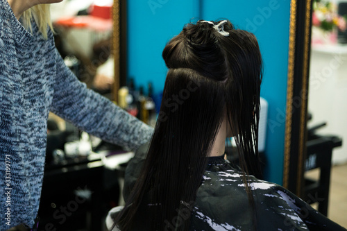 Closeup hairdresser coiffeur makes hairstyle. No face in the scene. © Sebastian88