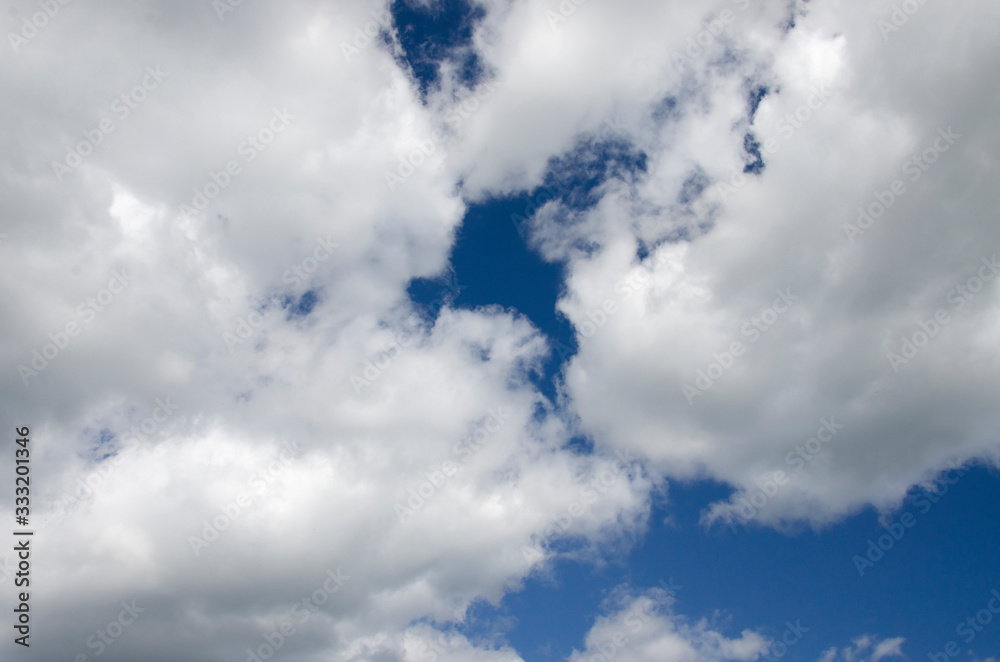 White fluffy clouds on the dark blue sky White fluffy clouds on the dark blue sky
