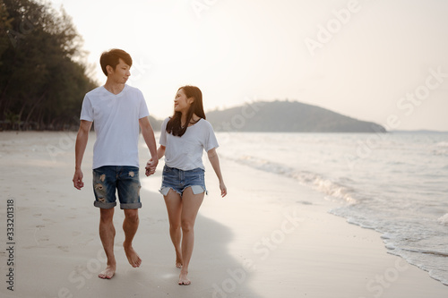 Romantic couple walking holding hands each other while at beach at sunrise, plan life insurance at future concept. copy space for text. couple, love, beach, romantic, summer, lifestyle concept.