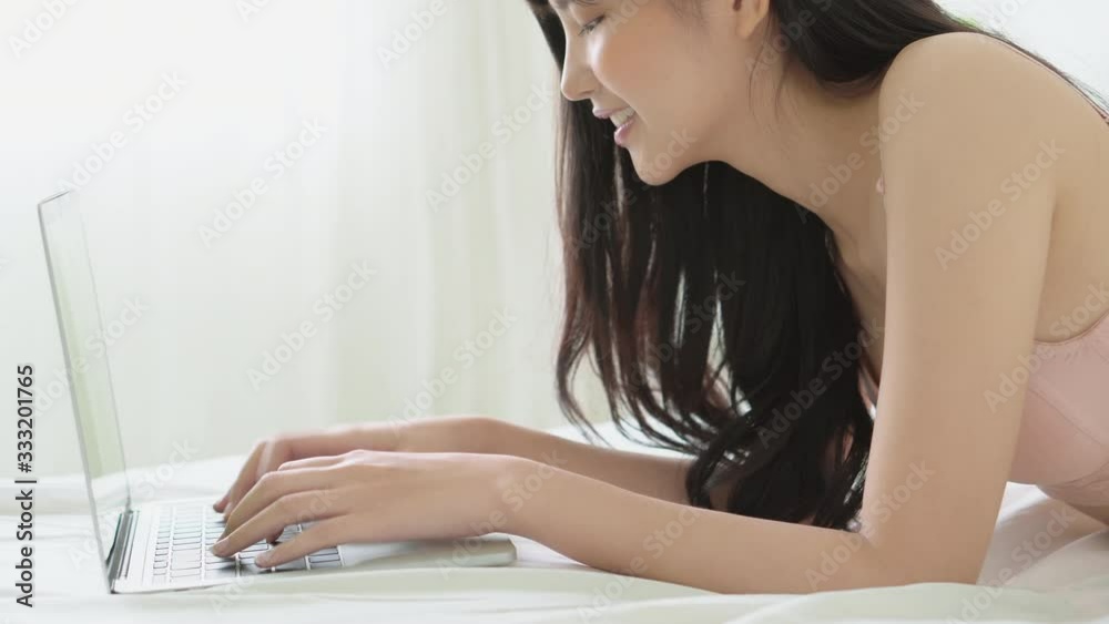 Beautiful young asian sexy woman excited using work with laptop computer surfing to internet online and lying on bed at room, asia girl leisure typing and chat with cheerful, communication concept. Beautiful young asian sexy woman excited using work with laptop computer surfing to internet online and lying on bed at room, asia girl leisure typing and chat with cheerful, communication concept.