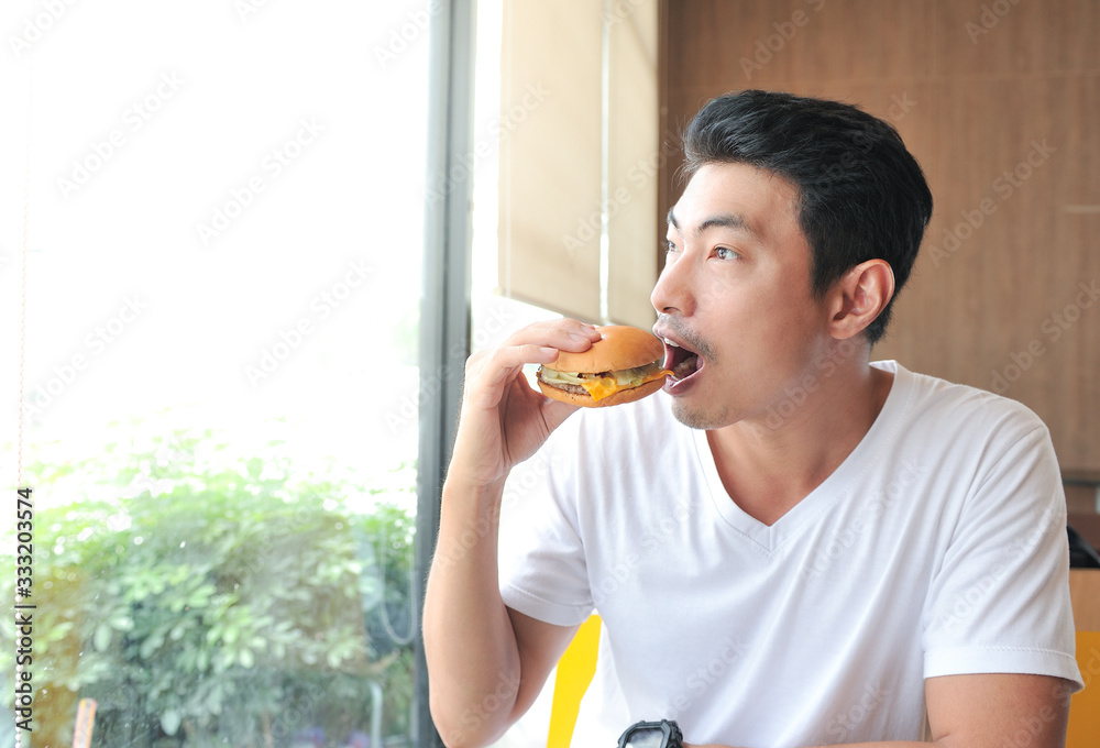 custom made wallpaper toronto digitalA man enjoy eating with her burger in hands,Asian man open his mouth for biting burger,Men eat burgers without knowing the danger of Junk Food.,Selective focus
