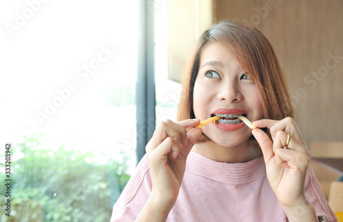 Wallpaper Mural A women smile and biting her french fries,Happy with meal,Selective focus Torontodigital.ca