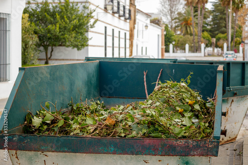 Foto Metal skip filled with green waste on the road in Llerena Spain