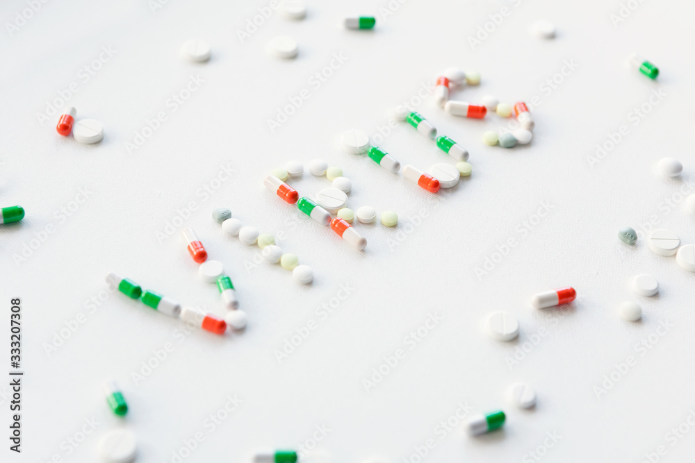 Words in English NCov and Virus made from multi-colored pills on white background. Pharmacological and health protection concept. Words in English NCov and Virus made from multi-colored pills on white background. Pharmacological and health protection concept.