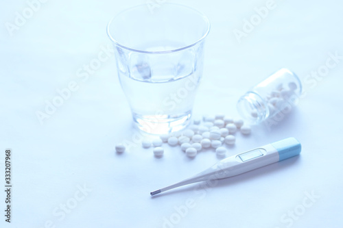 白いイメージ 錠剤と体温計とコップの水