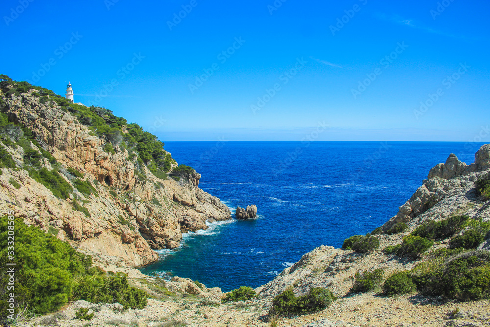 Faro de Capdepera lighthouse on top of cliffs in Cala Gat near Cala Rajada, Mallorca, Spain