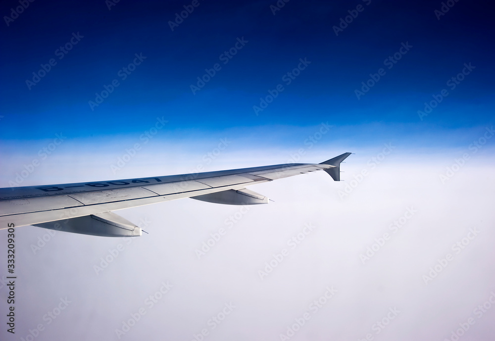 wing of airplane flying above clouds wing of airplane flying above clouds