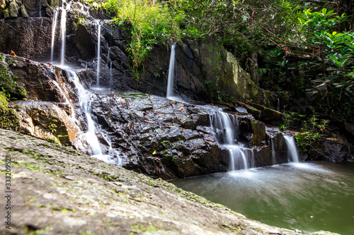 Fototapeta Naklejka Na Ścianę i Meble -  Water flows down the rocks. Waterfall in a park.