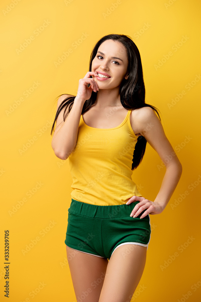 attractive cheerful girl in green shorts on yellow attractive cheerful girl in green shorts on yellow