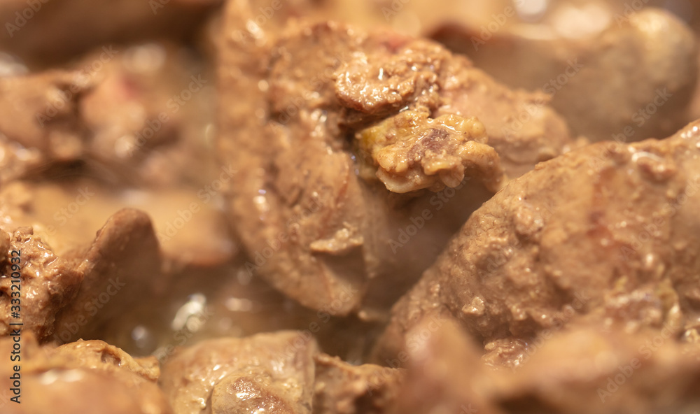 Chicken liver is fried in a pan.