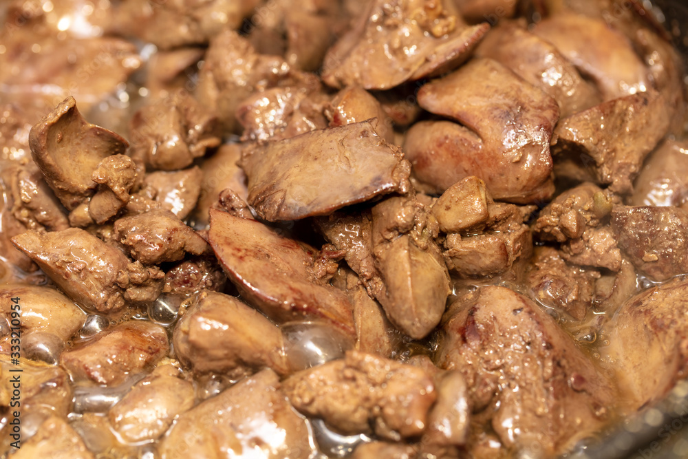 Chicken liver is fried in a pan.
