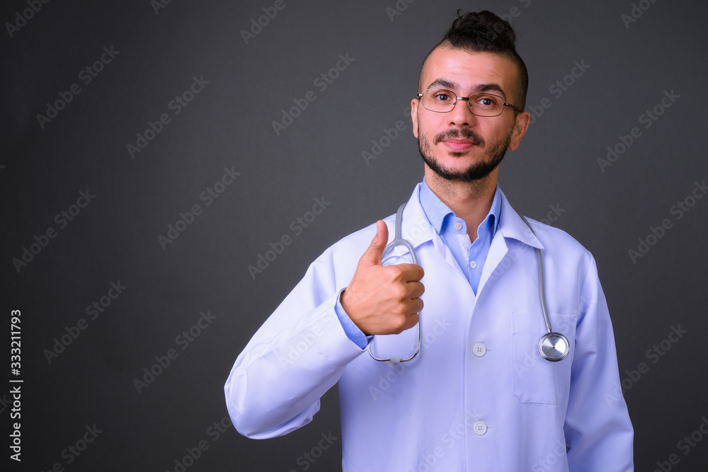 Portrait of handsome bearded Turkish man doctor giving thumbs up Portrait of handsome bearded Turkish man doctor giving thumbs up