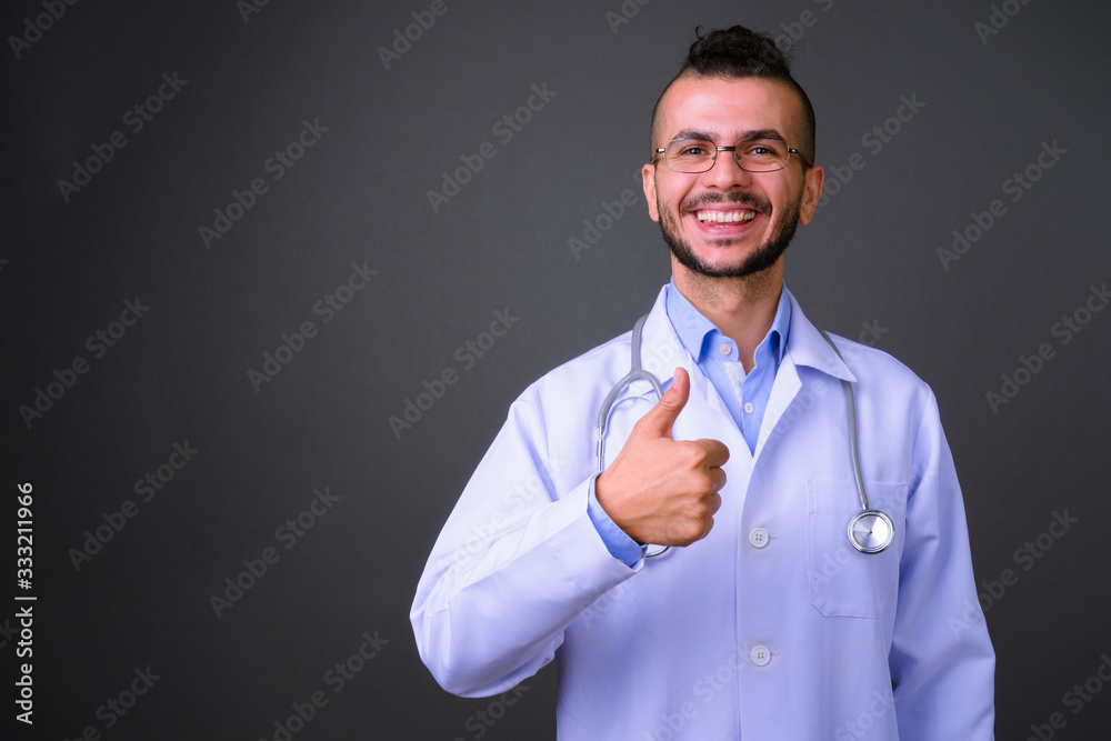 Portrait of happy bearded Turkish man doctor giving thumbs up Portrait of happy bearded Turkish man doctor giving thumbs up
