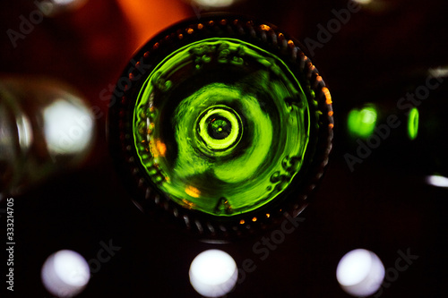 Green bottoms of wine bottles illuminated by bright light