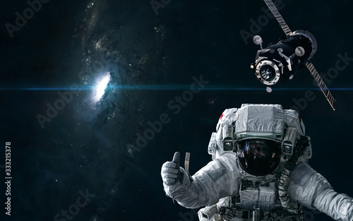 Fototapeta Naklejka Na Ścianę i Meble -  Astronaut, space station on the background of a bright star in the center of the galaxy. Science fiction. Elements of this image furnished by NASA