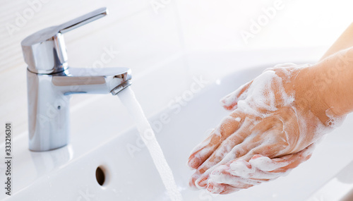 Fototapeta Naklejka Na Ścianę i Meble -  Woman use soap and washing hands under the water tap. Hygiene concept hand detail.