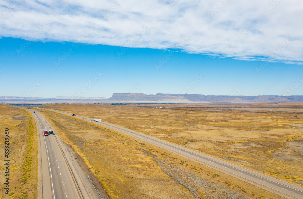 Aerial top view of nature landscape. Blue sky with clouds, highway road, mountains, on background. USA Aerial top view of nature landscape. Blue sky with clouds, highway road, mountains, on background. USA