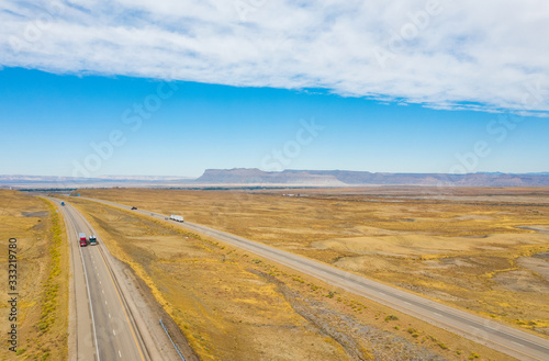 Aerial top view of nature landscape. Blue sky with clouds, highway road, mountains, on background. USA
