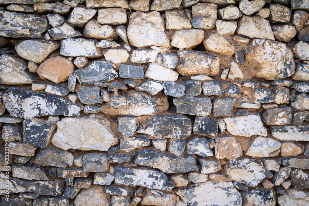 Natural stone wall for backdrop texture, white grey beige color, wallpaper. Vintage strong stone block wall of many shapes and sizes. Natural stone wall for backdrop texture, white grey beige color, wallpaper. Vintage strong stone block wall of many shapes and sizes.