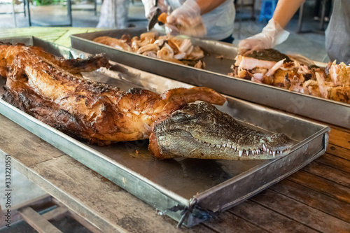 Whole skinless roasted crocodile on a metal baking sheet