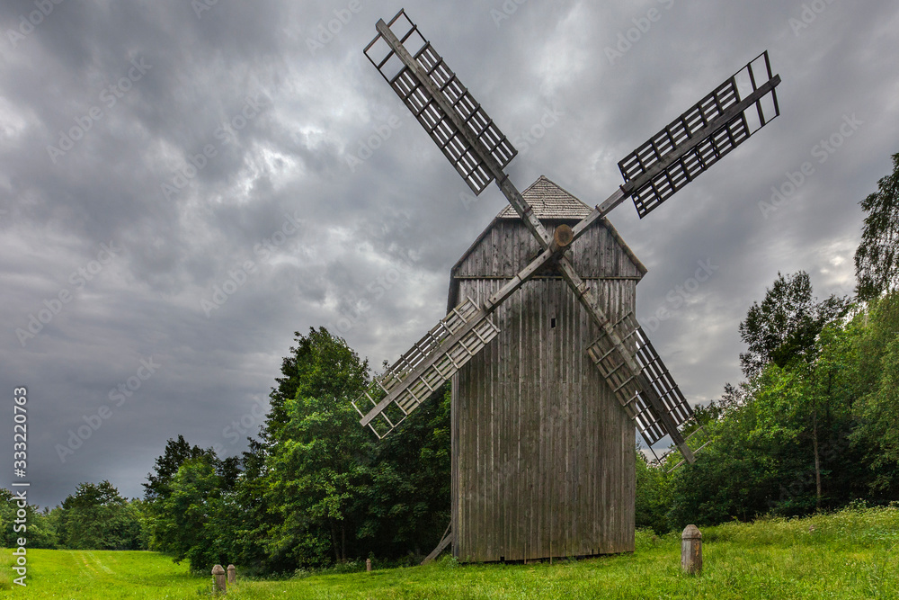 Windmill in a village near forest for print