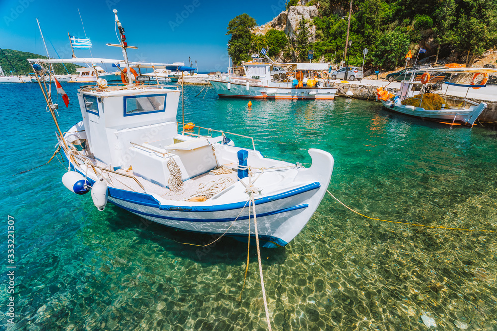 Traditional fishing boat in crystal clear Mediterranean sea cove of Ithaka island, Greece - obrazy, fototapety, plakaty 