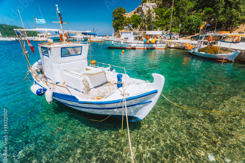Traditional fishing boat in crystal clear Mediterranean sea cove of Ithaka island, Greece photo