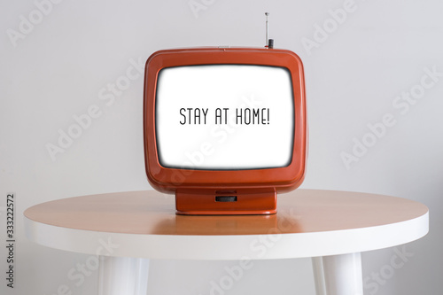 STAY HOME text or message to citizens (people) of the country and the world in an old retro TV screen on the table. Creative. concept. photo