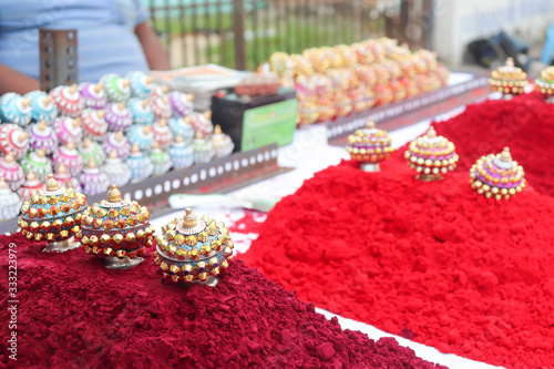 Flower Design Round Shaped Antique Decorative Ornamental Sindoor Box On Top Of Maroon Color  Vermilion Or Sindoor Sindura For Married Women In India With Blur Background photo