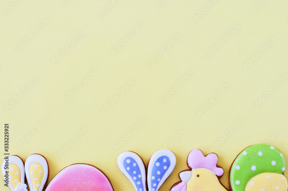 Easter background concept. Colored easter cookies on yellow background.