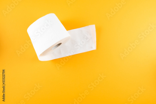 directly above shot of single roll of toilet paper on orange background