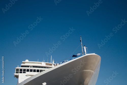 The front of a white cruise ship on a background of blue sky