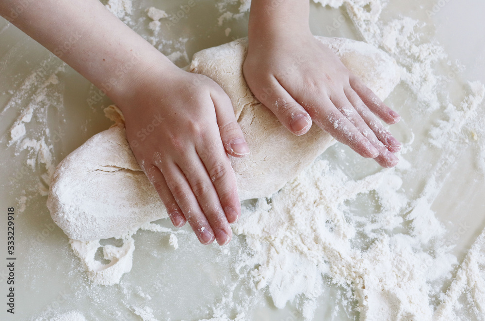 Making dough from flour. The child kneads the dough closeup Making dough from flour. The child kneads the dough closeup