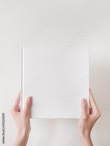 White book mockup. Square empty book. Album with clean pages in hands of woman. Clean book cover mockup