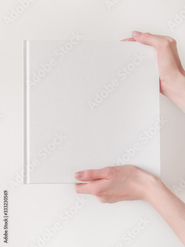 White book mockup. Square empty book. Album with clean pages in hands of woman. Clean book cover mockup