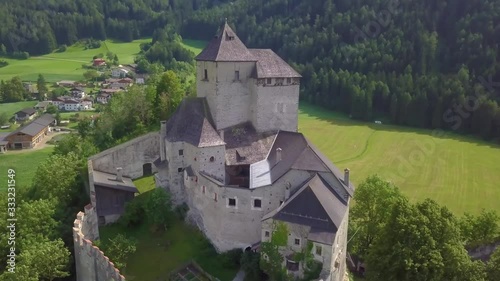 An 4K aerial view over old castle. A medieval building in northern Italy, at the foot of the Alps, flying around photo