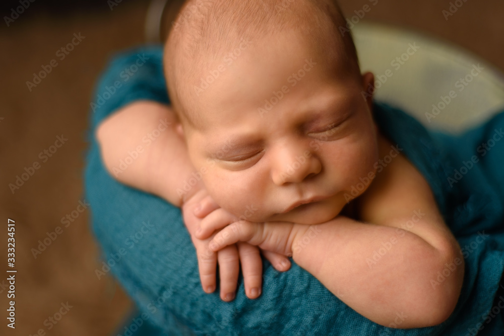 Beautiful newborn baby resting her hands on her face