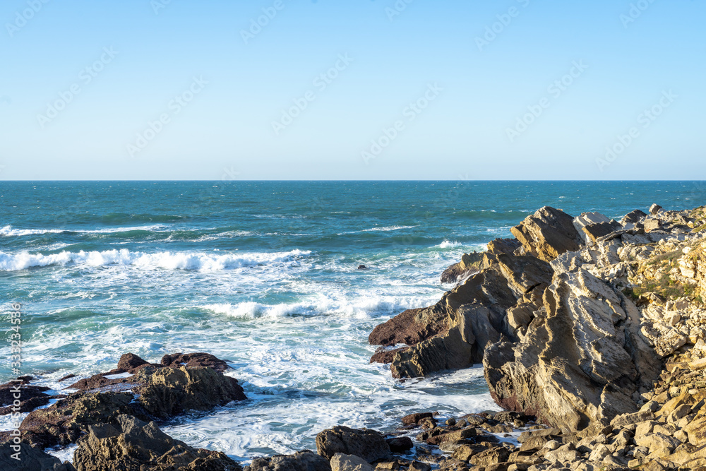 Ocean waves against coastline cliffs.